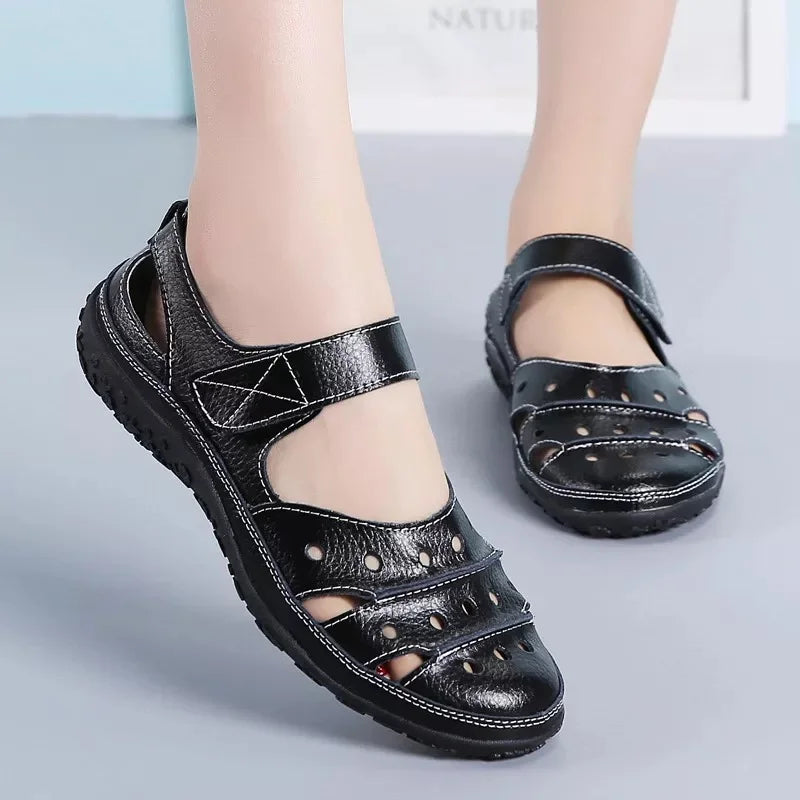 Flat sandals in hollowed-out leather