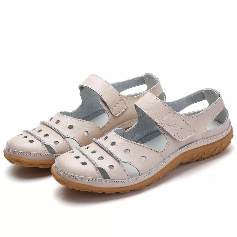 Flat sandals in hollowed-out leather