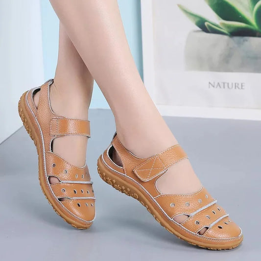 Flat sandals in hollowed-out leather