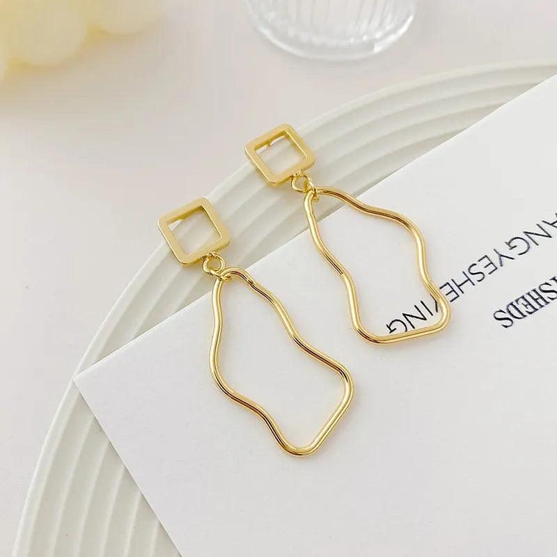 Asymmetric baroque pearl earrings with gold accents